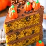 A slice of Pumpkin Chocolate Chip Layer Cake next to a fork on a gray plate