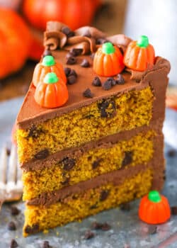 A slice of Pumpkin Chocolate Chip Layer Cake next to a fork on a gray plate