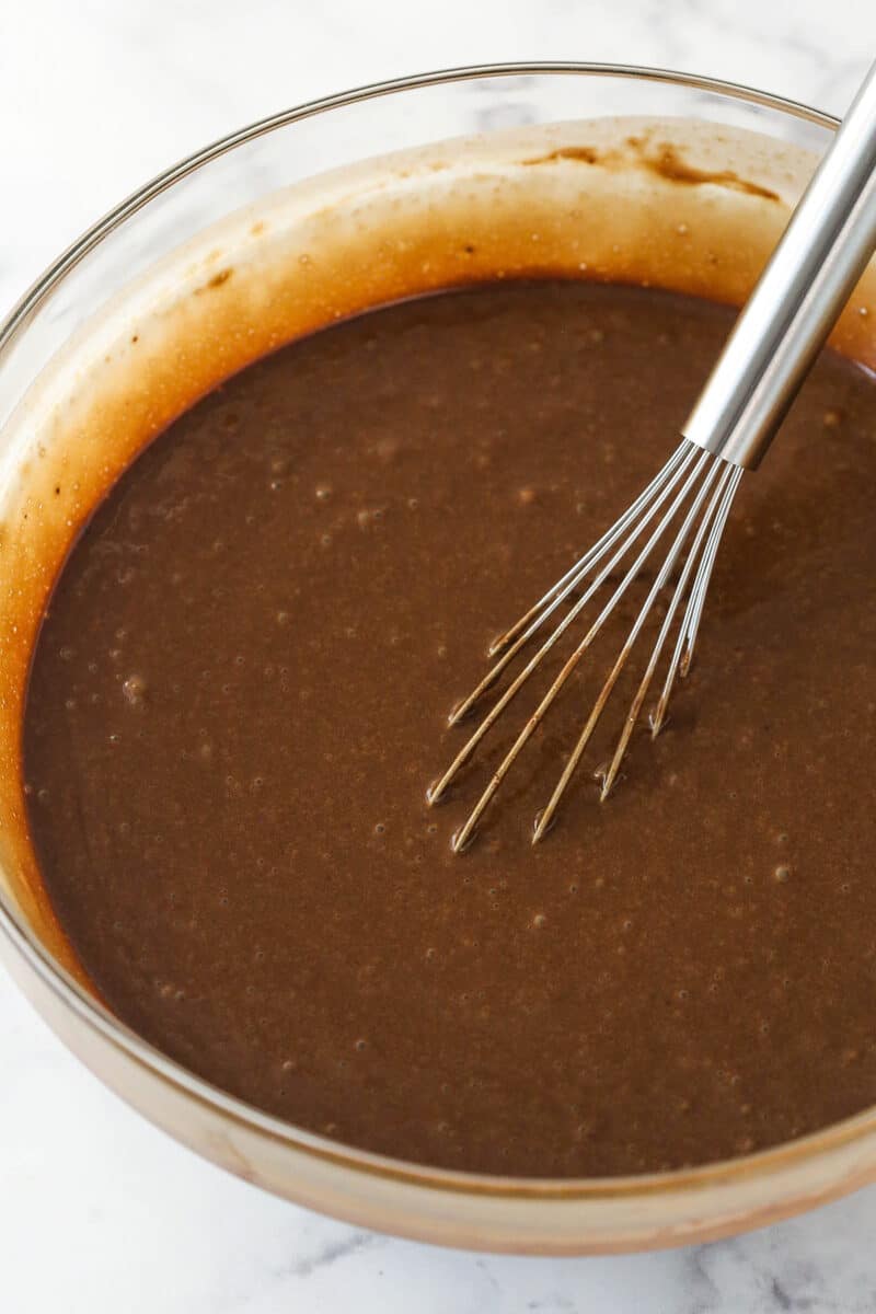 Whisking vanilla and red wine into chocolate cake batter.