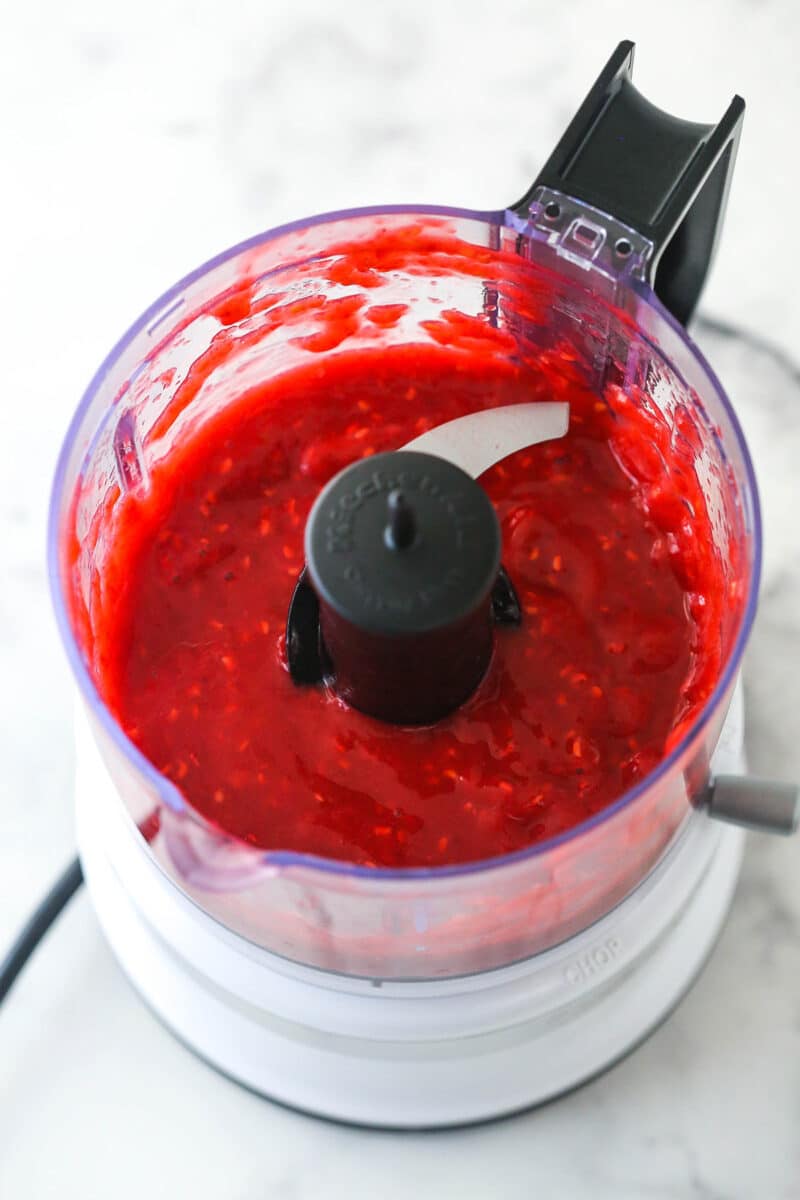 Pureeing raspberries in a food processor.