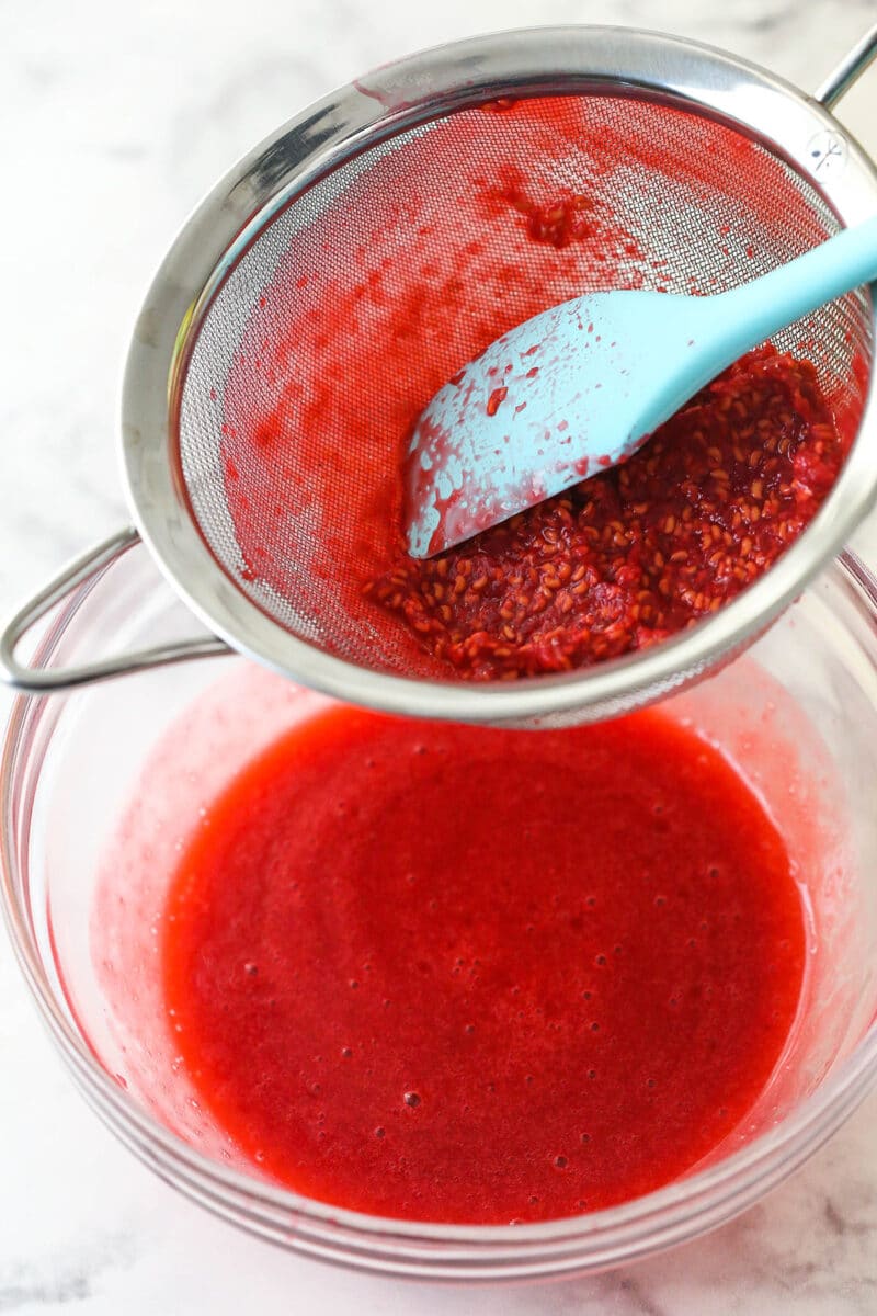 Straining seeds out of raspberry puree.