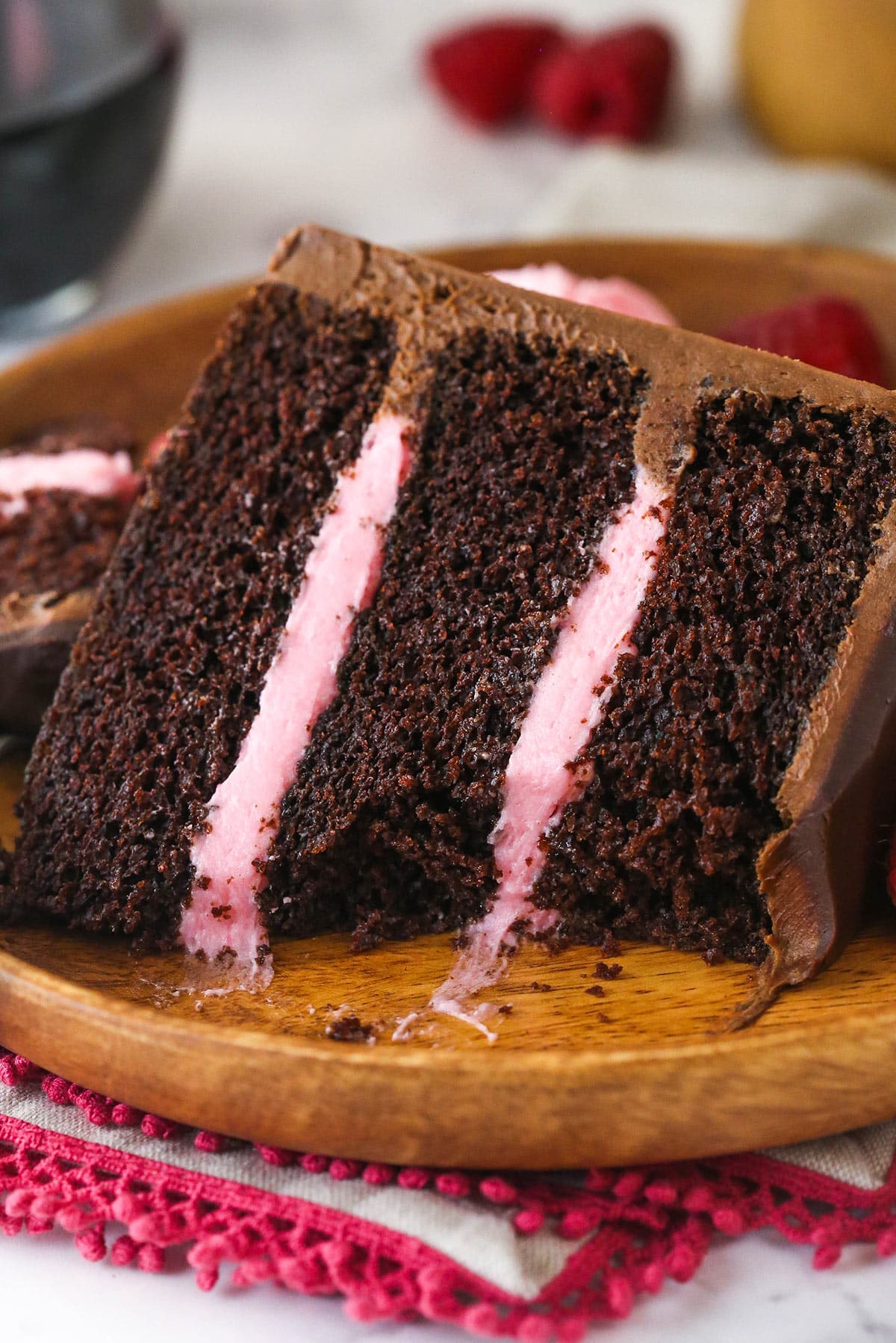 A slice of red wine chocolate cake with a bite taken out of it.