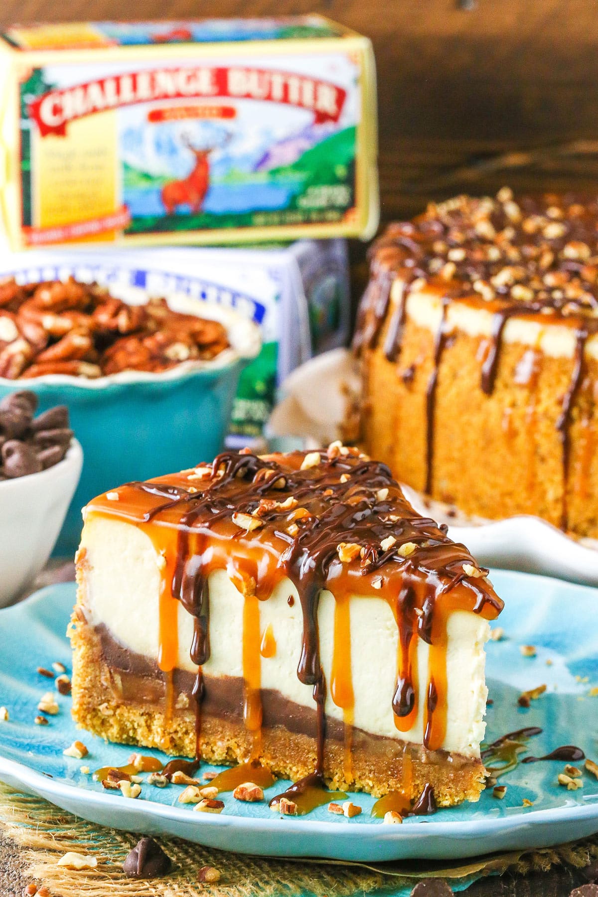 Side view of a slice of Turtle Cheesecake with Challenge Butter in the background