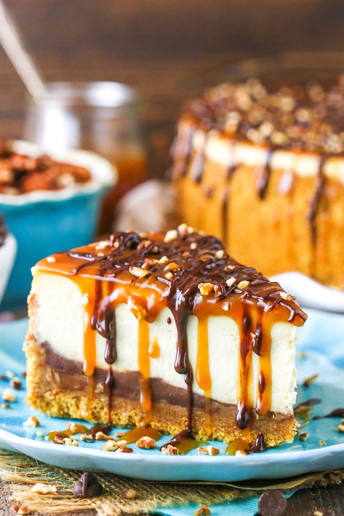 Side view of a slice of Turtle Cheesecake on a blue plate