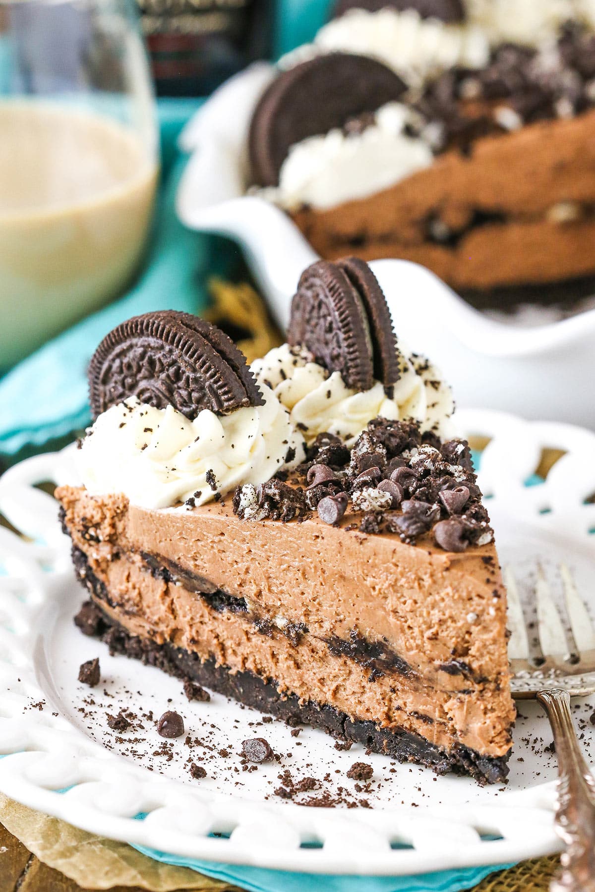 A slice of Baileys Chocolate Cream Pie next to a silver fork on a white plate