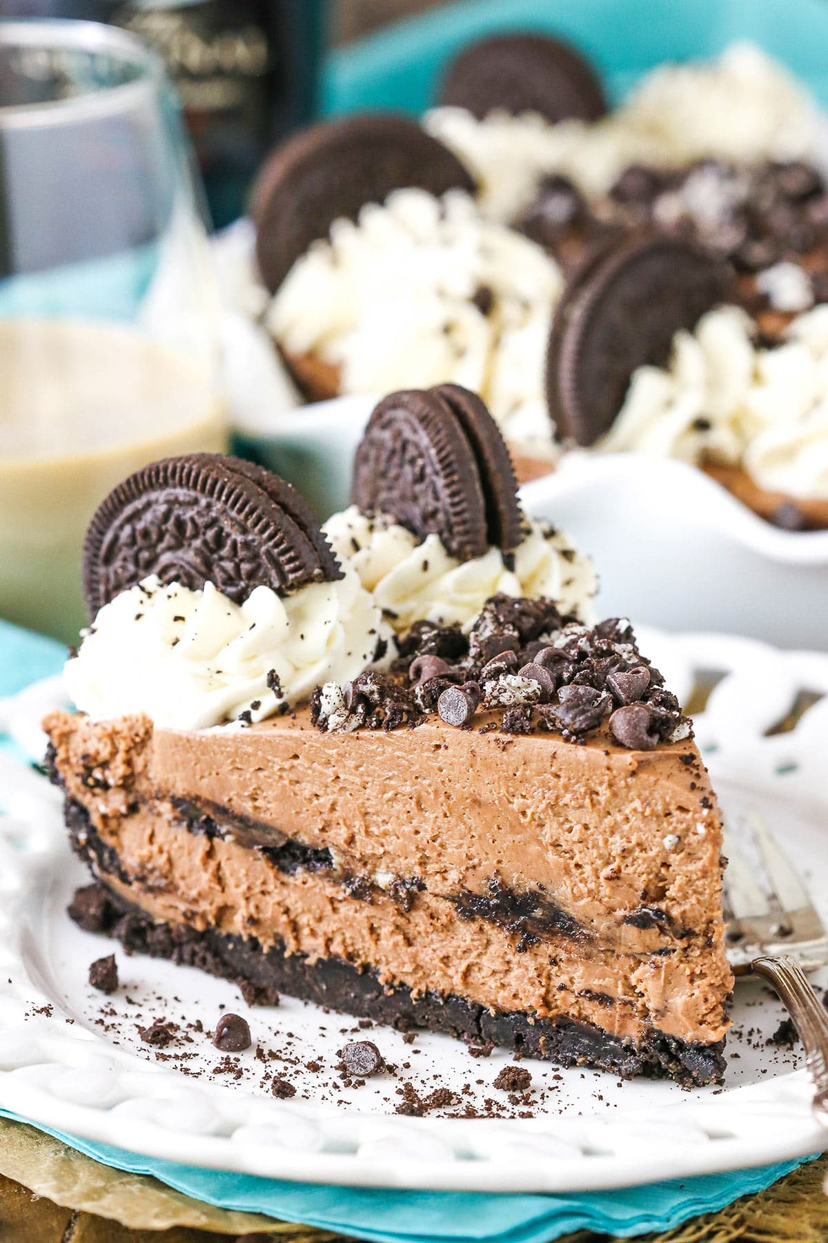 A slice of Baileys Chocolate Cream Pie next to a silver fork on a white plate