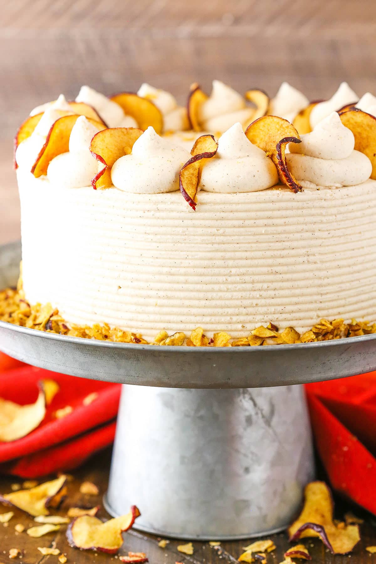 Side view of a full Cinnamon Apple Layer Cake on a gray cake stand