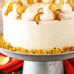 Side view of a full Cinnamon Apple Layer Cake on a gray cake stand