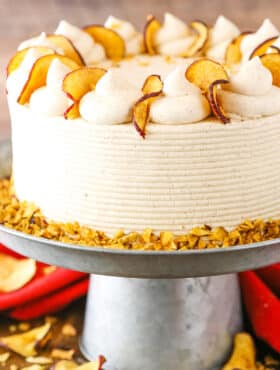 Side view of a full Cinnamon Apple Layer Cake on a gray cake stand