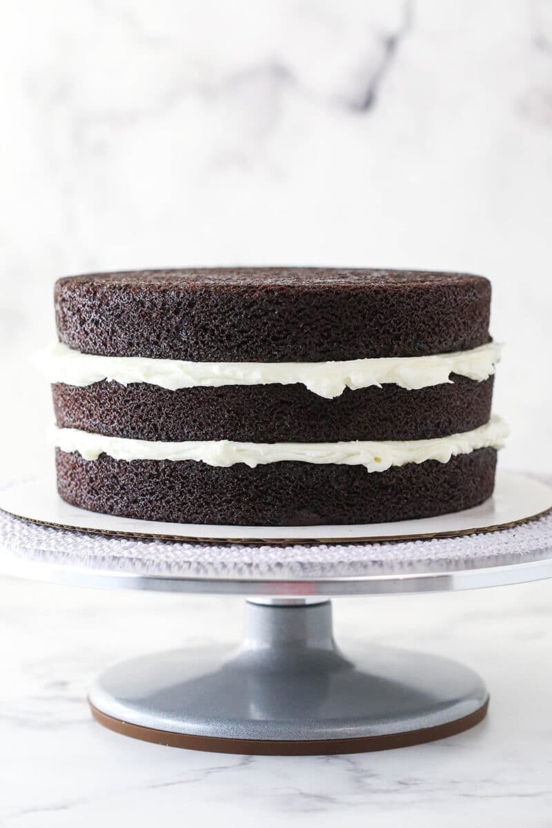 3 layers of chocolate cake stacked on top of one another divided by coconut buttercream.
