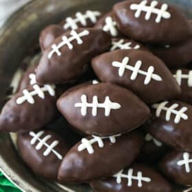 Closeup overhead image of cookie dough footballs on a serving plate.