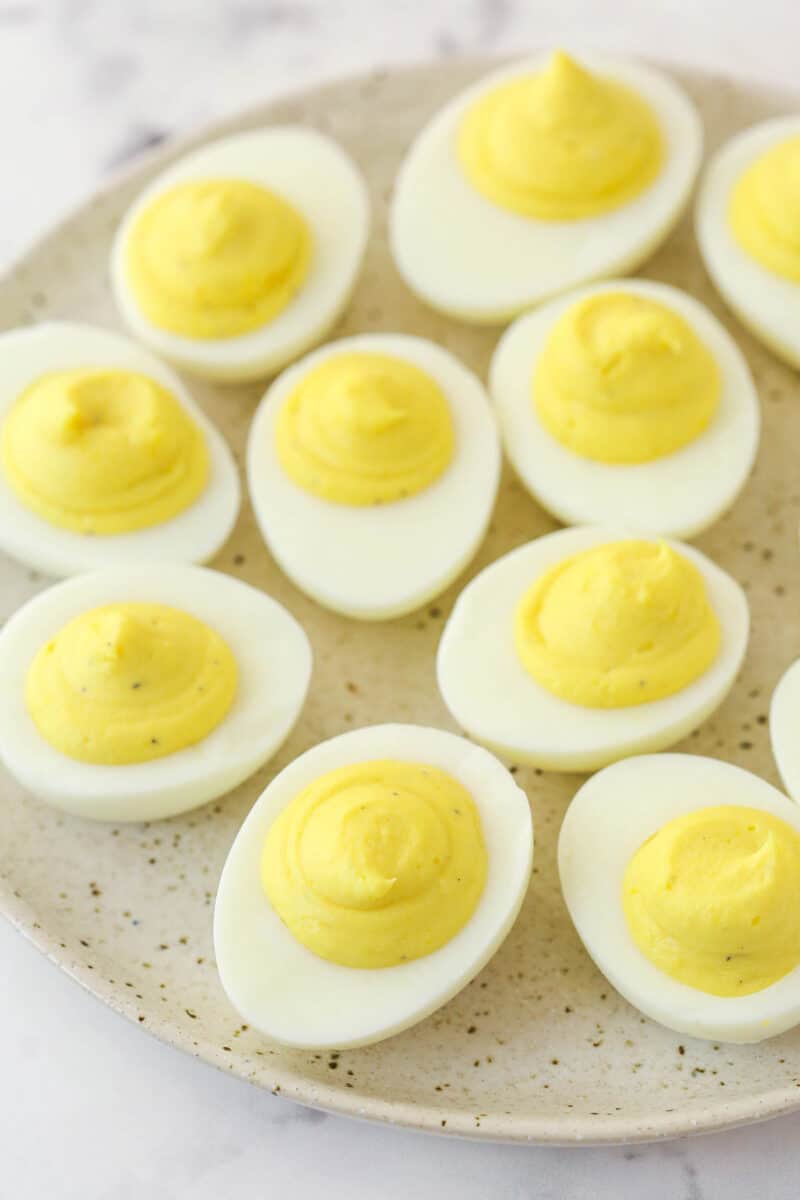 Deviled eggs on a serving platter before being garnished with paprika.