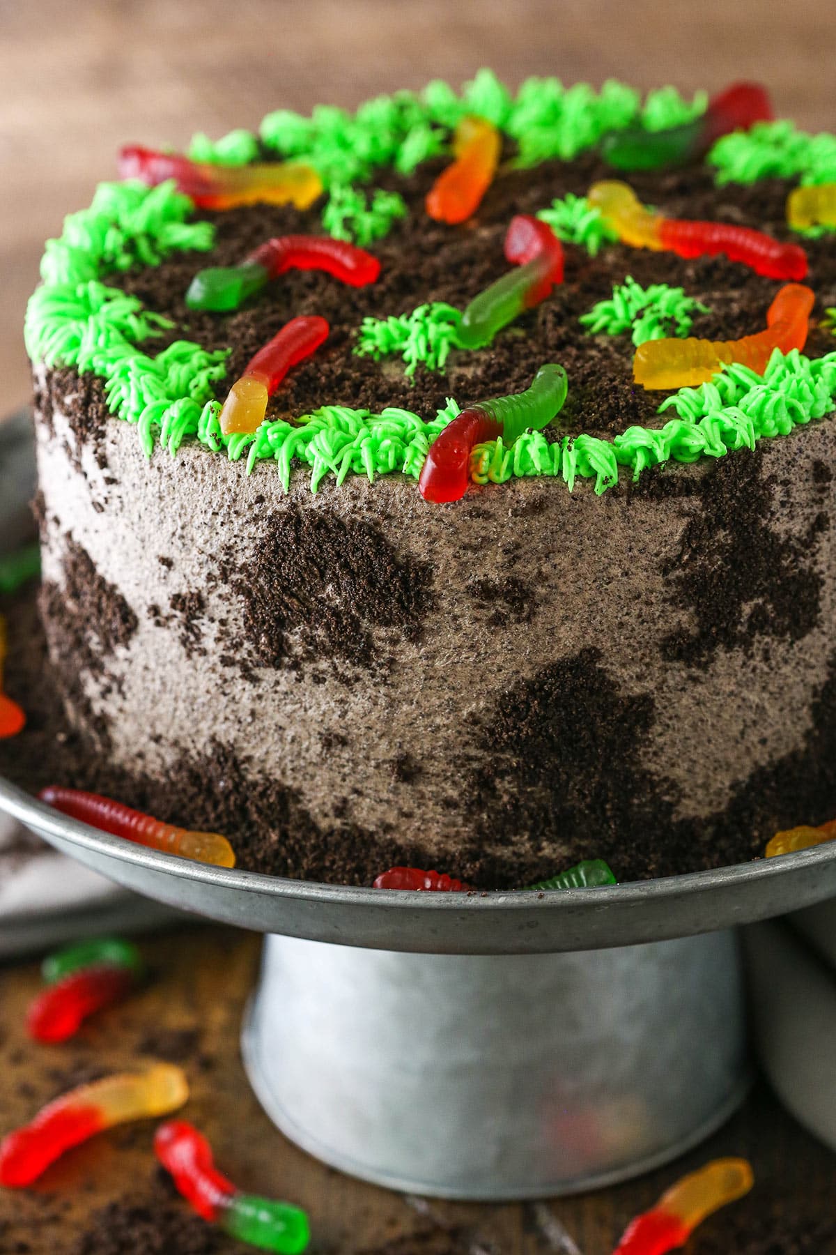 Side view of a full Dirt Cake on a gray cake stand