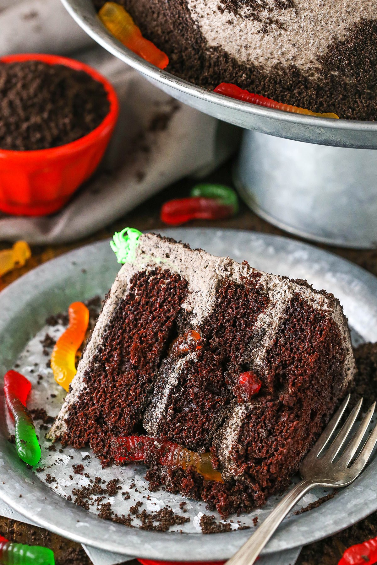 A slice of Dirt Cake next to a silver fork on a gray plate