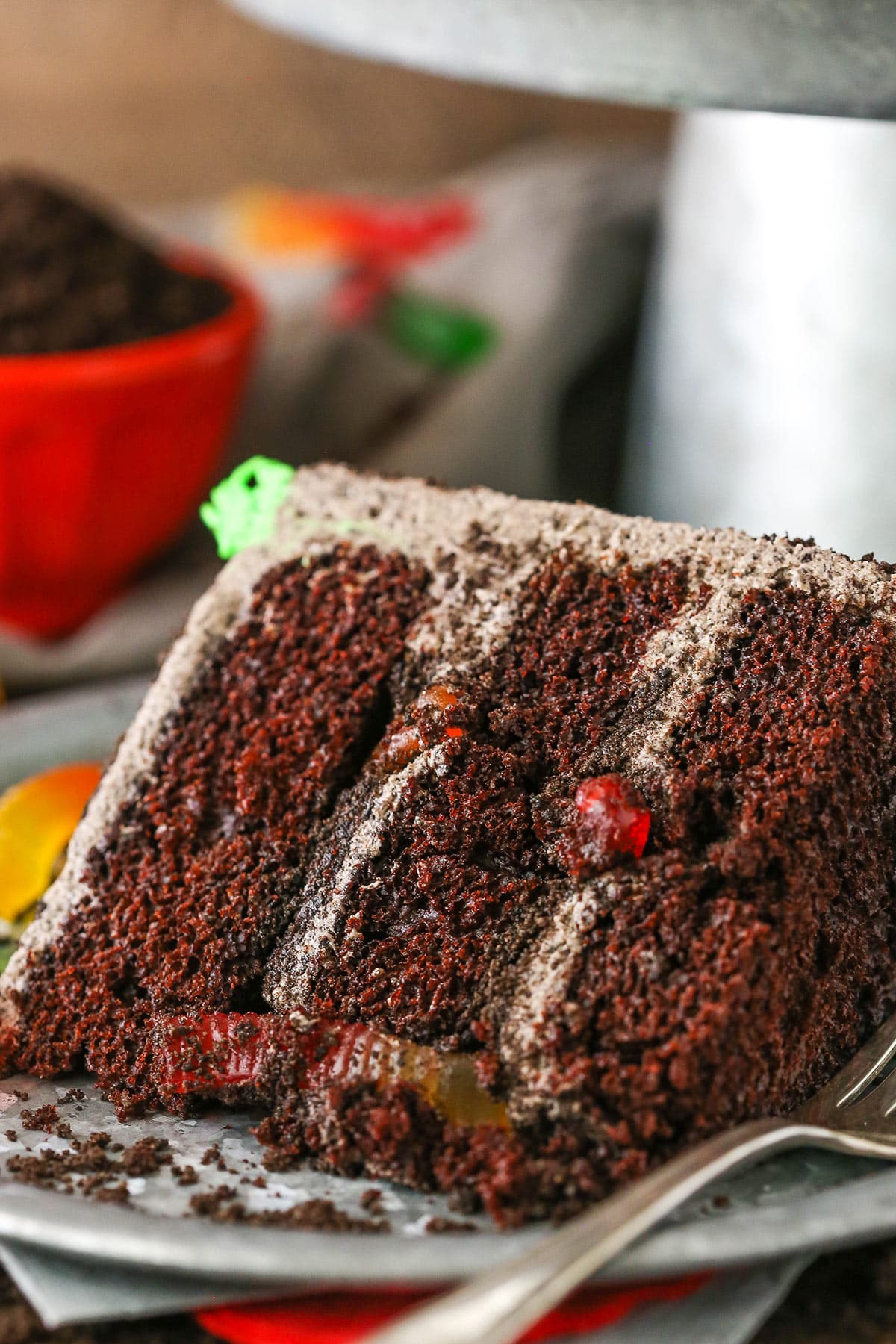 A slice of Dirt Cake next to a silver fork on a gray plate