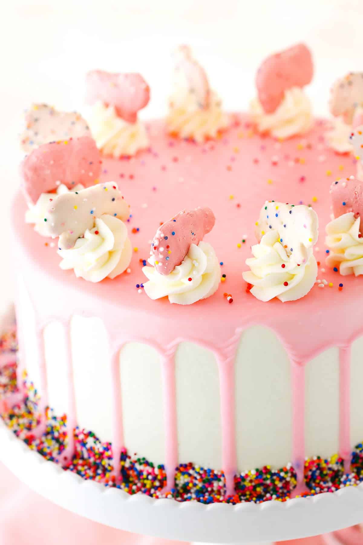 Close up of a full Frosted Circus Animal Cookie Cake on a white cake stand