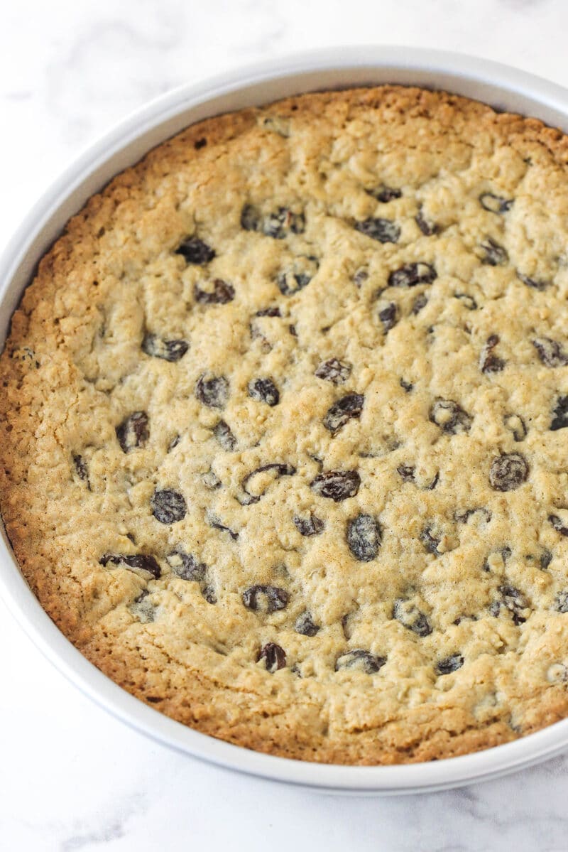 Oatmeal raisin cookie cake is soft and chewy, loaded with warming cinnamon and sweet raisins, and topped with the best maple buttercream. Oatmeal raisin cookie cake cooling in a cake pan.