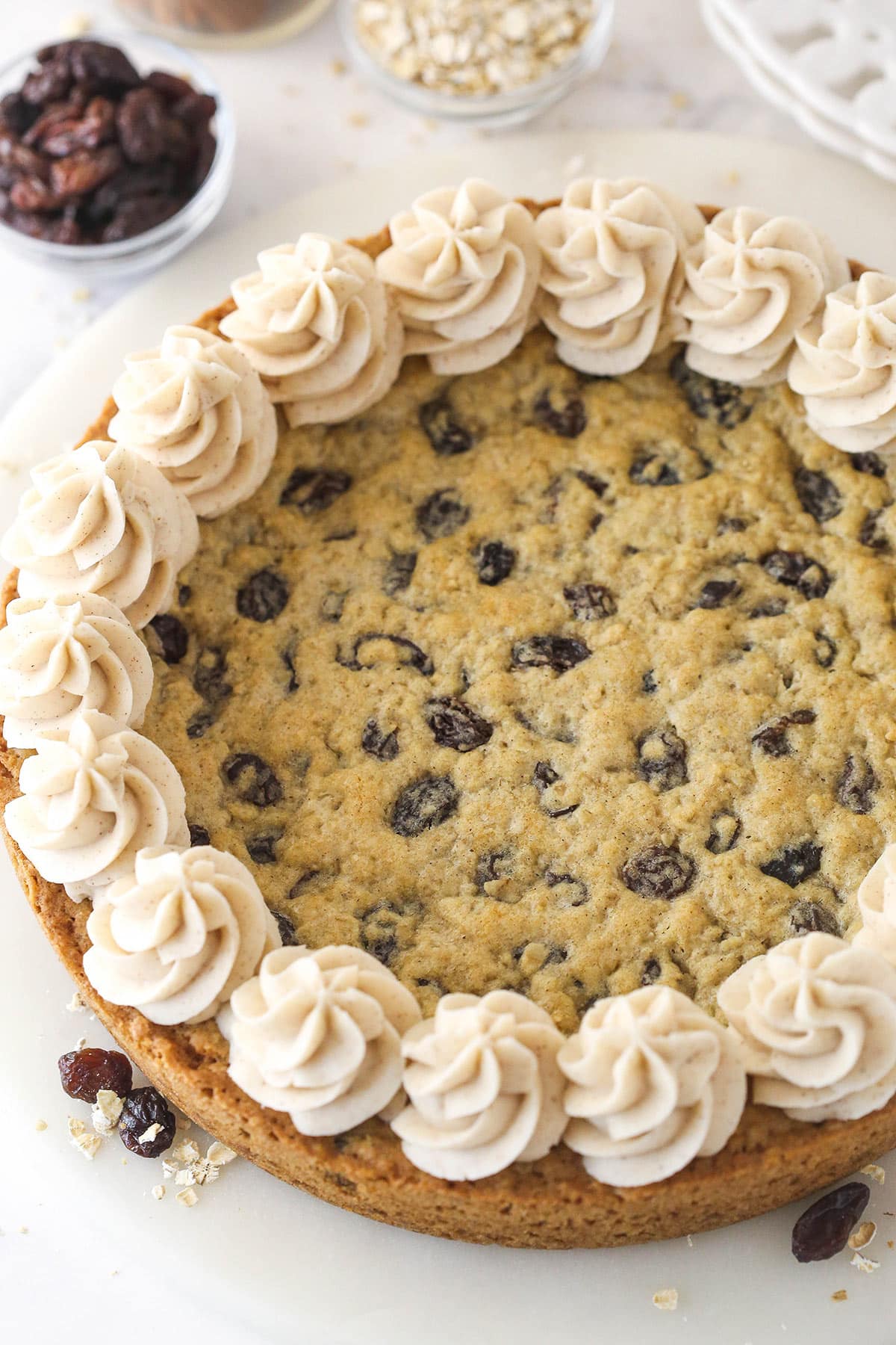 Oatmeal raisin cookie cake is soft and chewy, loaded with warming cinnamon and sweet raisins, and topped with the best maple buttercream. Overhead image of oatmeal raisin cookie cake.