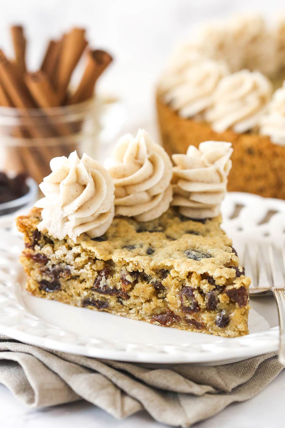 A slice of oatmeal raisin cookie cake on a plate with a fork.