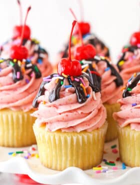 Closeup image of strawberry sundae cupcakes on a serving platter.