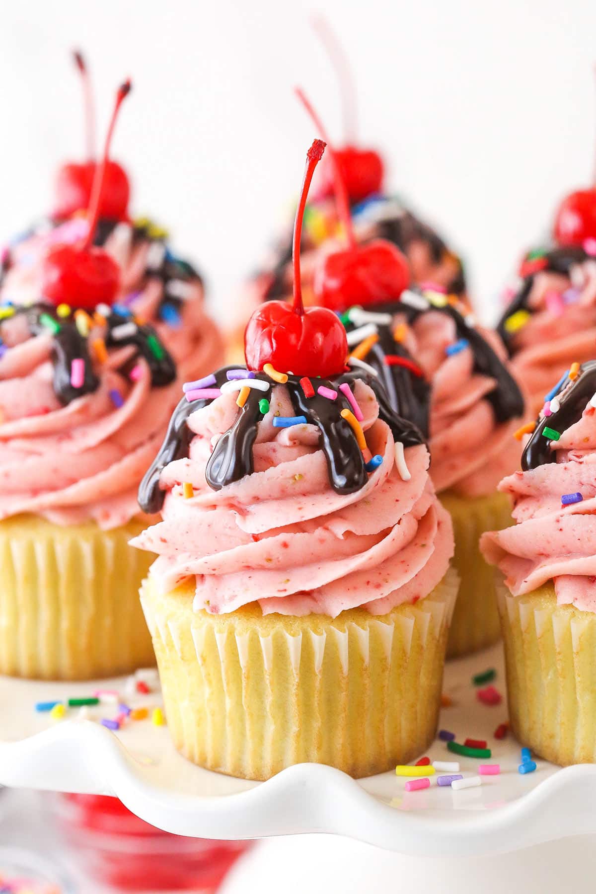 Closeup image of strawberry sundae cupcakes on a serving platter.