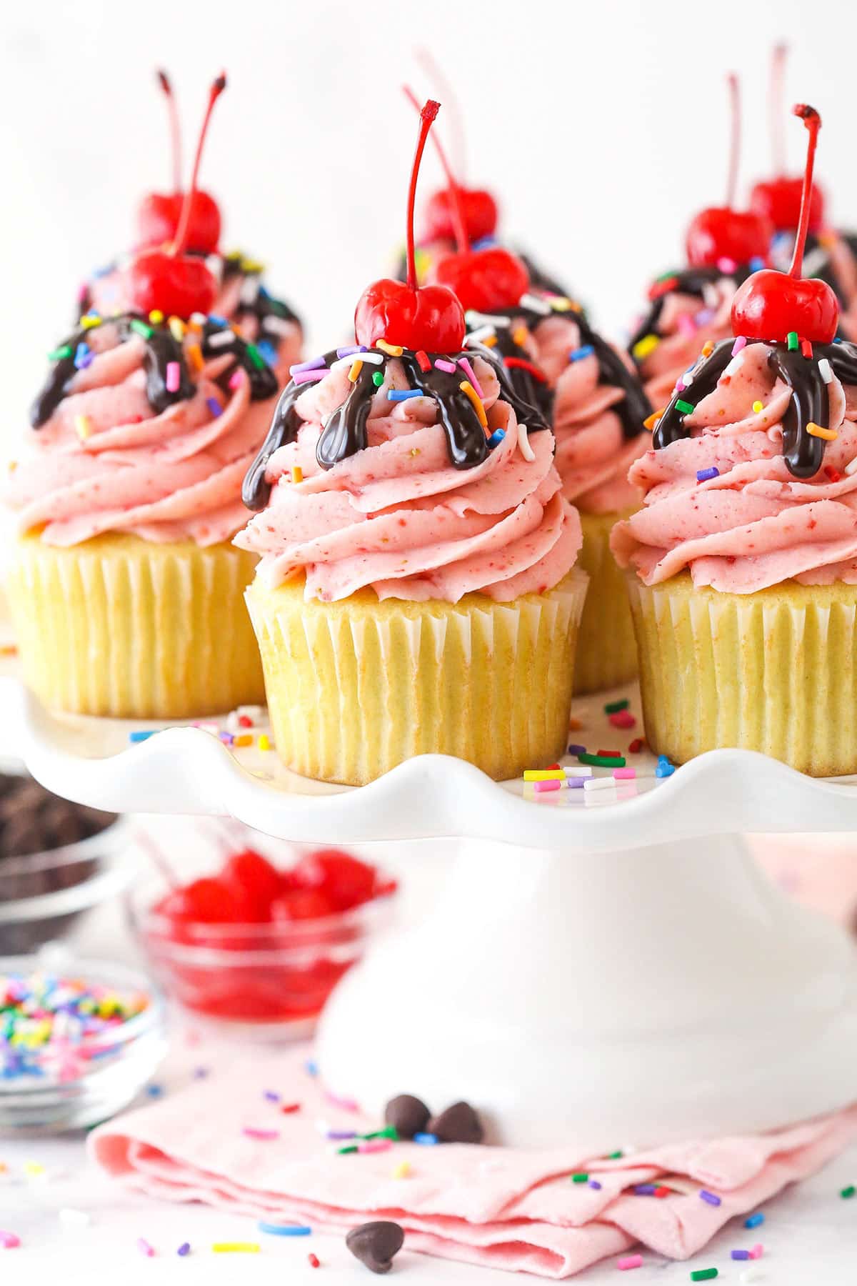 Strawberry sundae cupcakes on a serving platter.