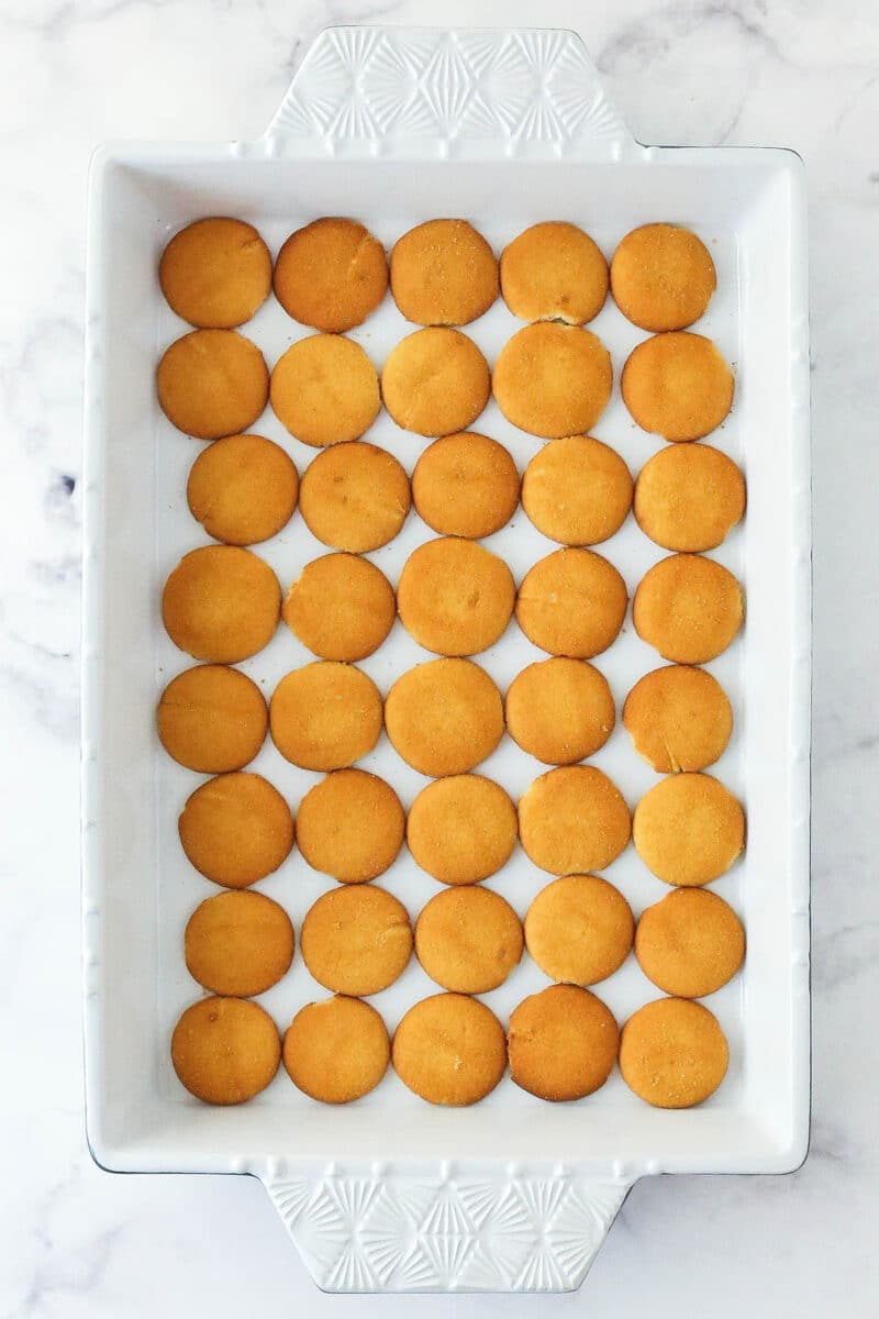 Adding a layer of vanilla wafers to the bottom of a baking dish.