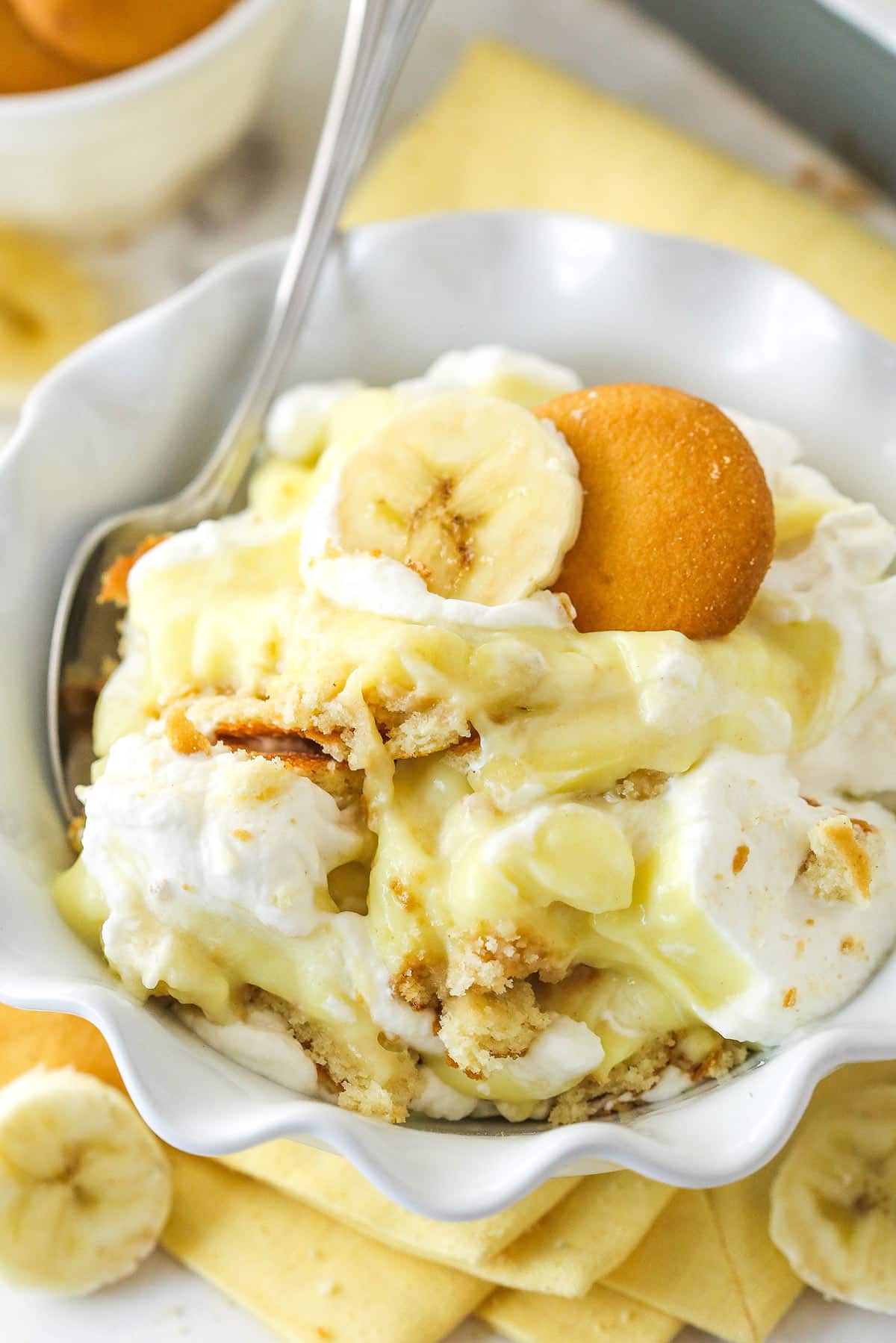 This from-scratch banana pudding is made of layers of vanilla wafers, banana slices, and thick, smooth banana flavor-infused vanilla pudding. Closeup of banana pudding in a bowl with a spoon.
