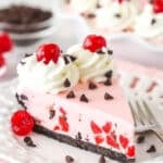 A slice of cherry chocolate ice cream pie on a plate with a fork.