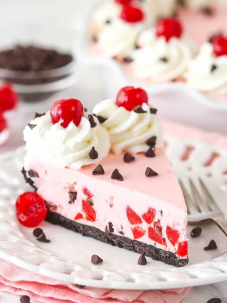 A slice of cherry chocolate ice cream pie on a plate with a fork.