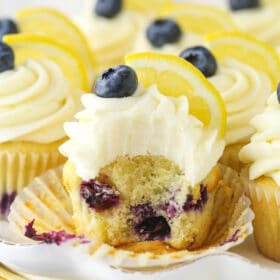 A lemon blueberry cupcake with a bite taken out of it.