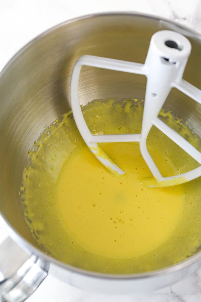 Beating together lemon zest and egg yolks.