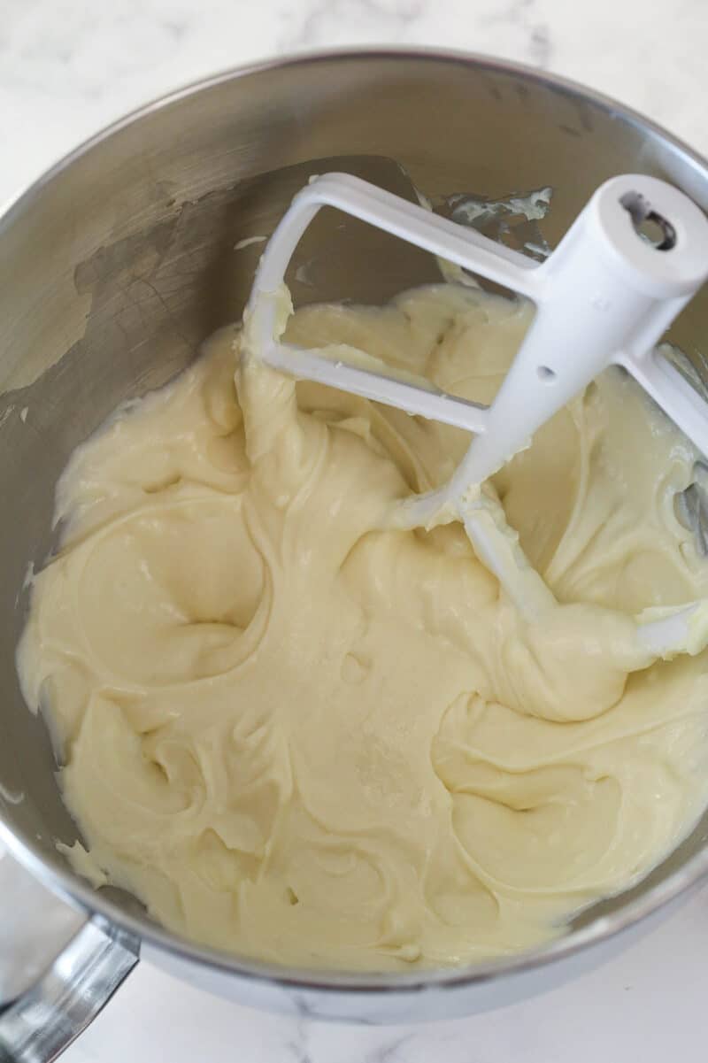 Mixing sour cream and vanilla into cheesecake batter.