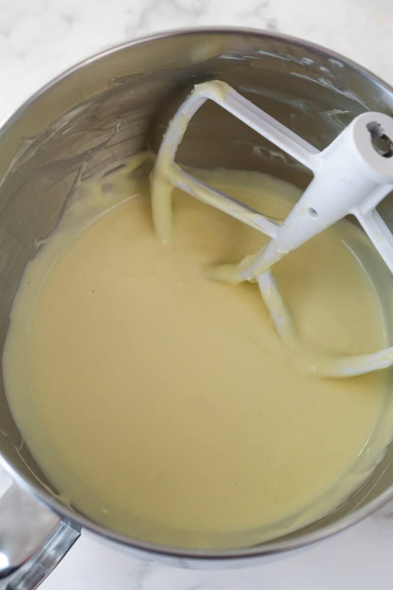 Mixing eggs into vanilla cheesecake batter.
