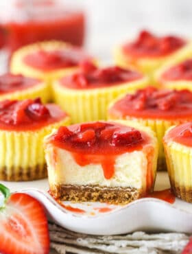 A mini strawberry cheesecake with a bite taken out of it.