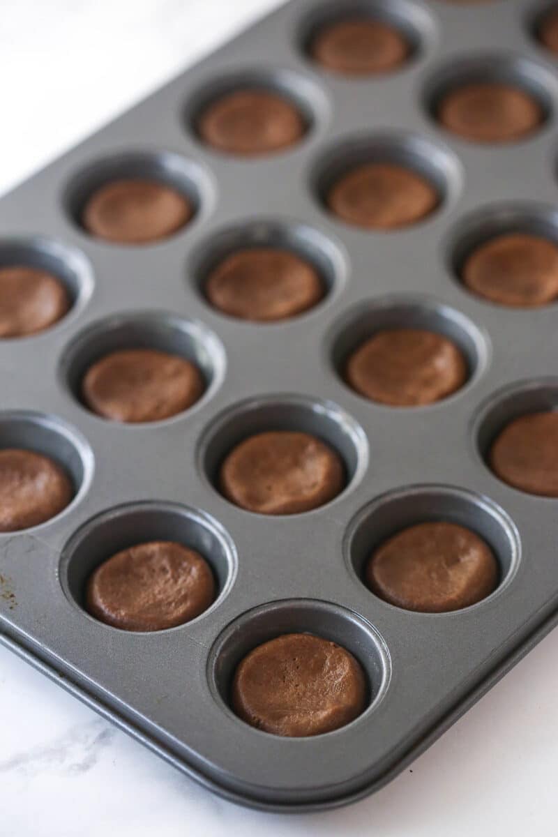 balls of cookie dough pressed into mini cupcake pan prior to baking