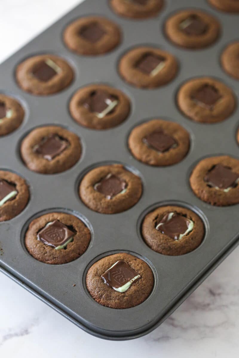 baked cookie cups in mini cupcake pan with Andes mints pressed into the middle