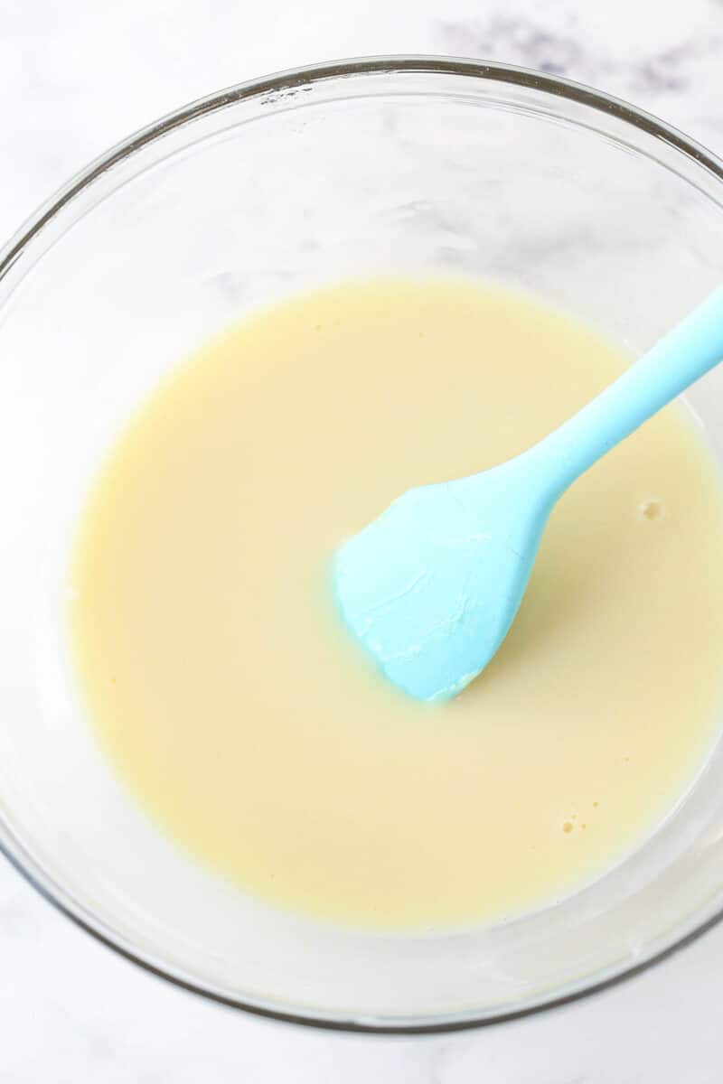 Stirring sweetened condensed milk into a mixture of lemon juice and gelatin.