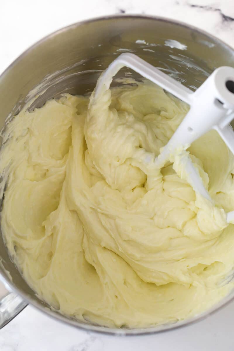 Mixing sour cream and lemon zest into cream cheese and sugar.