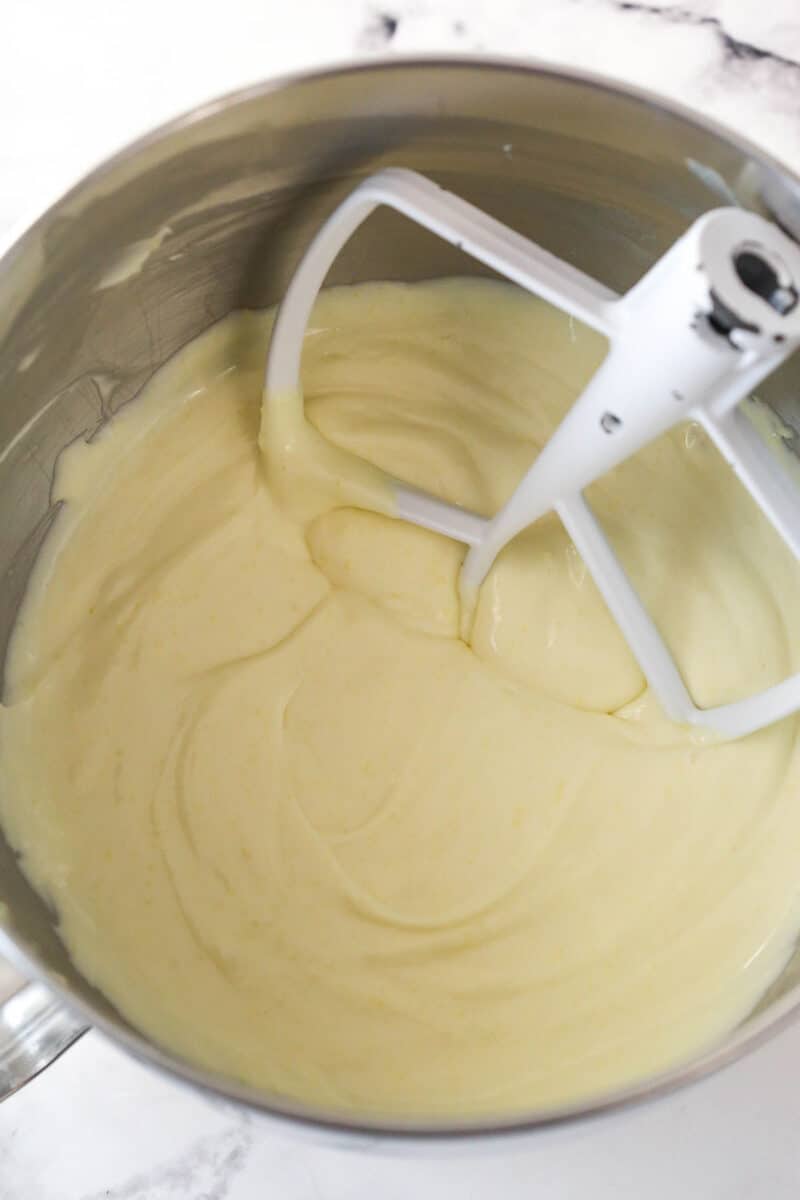 Mixing a mixture of lemon juice and gelatin into no bake lemon cheesecake filling.