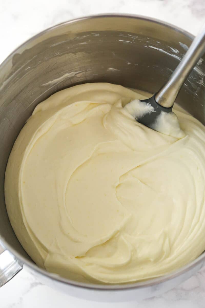 Folding whipped cream into no bake lemon cheesecake filling.