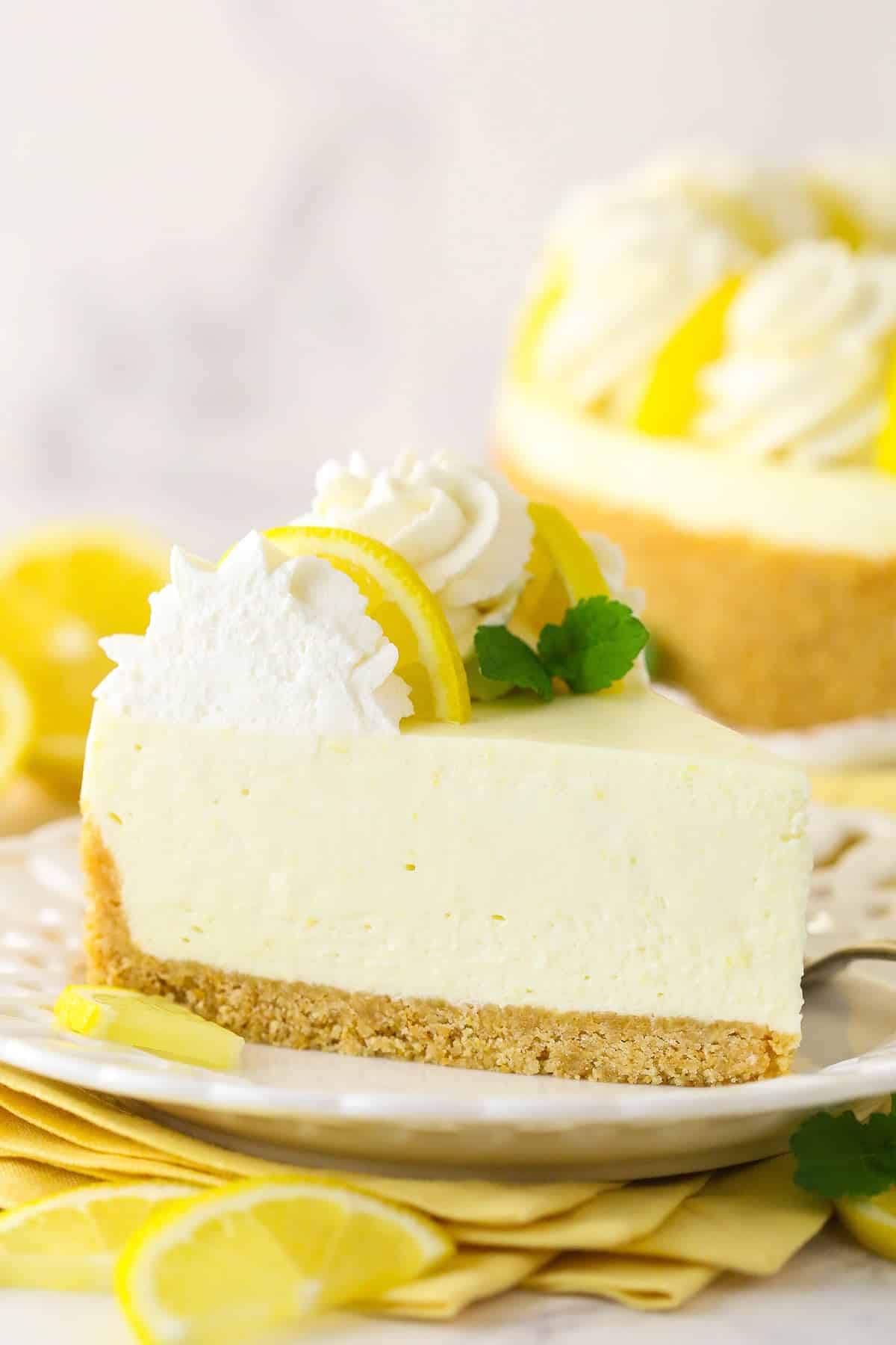 Side view of a slice of no bake lemon cheesecake on a plate.