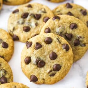 Closeup image of banana chocolate chip cookies scattered on a countertop.