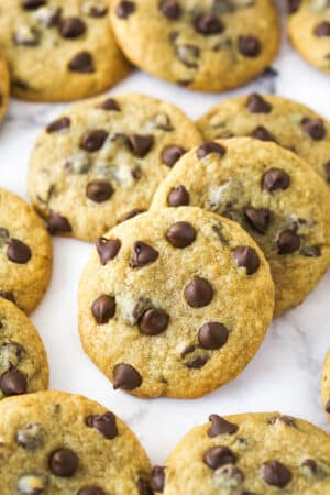 Closeup image of banana chocolate chip cookies scattered on a countertop.