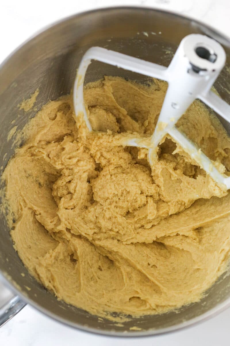 Mixing eggs into creamed butter and sugar for cookie dough.