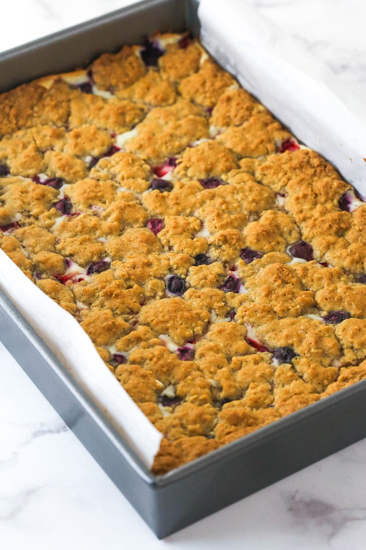 Berry oatmeal cheesecake bars in a baking pan.
