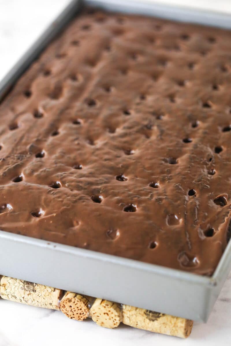 Chocolate sauce soaking into chocolate poke cake.