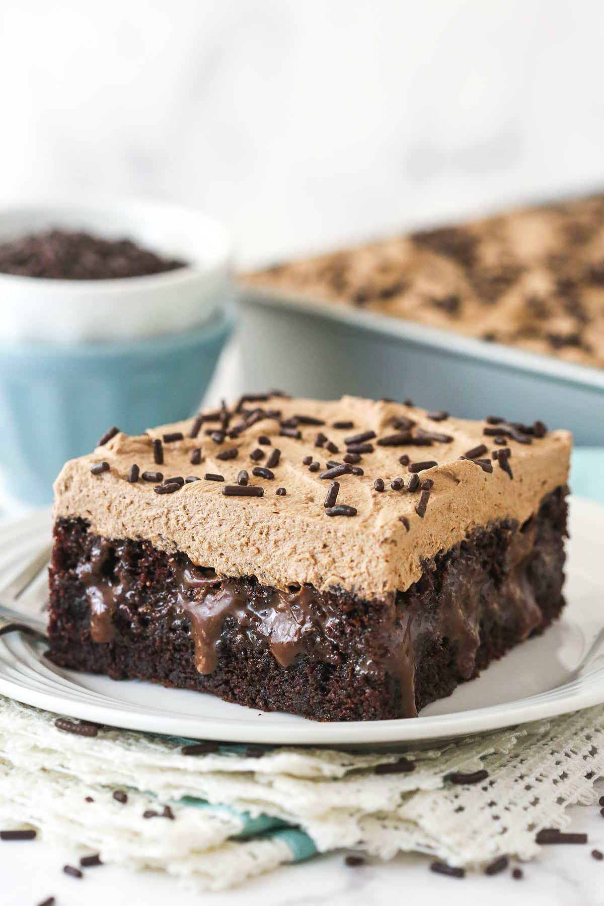 A slice of chocolate poke cake on a plate.