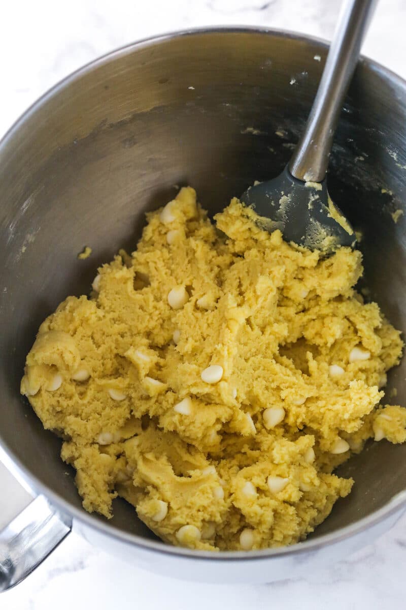 Folding white chocolate chips into lemon cookie cake dough.