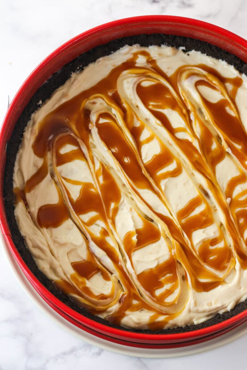 Swirling caramel sauce into a layer of no-bake Samoa cheesecake batter.